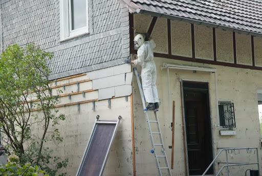 PPE-clad man inspecting a wall